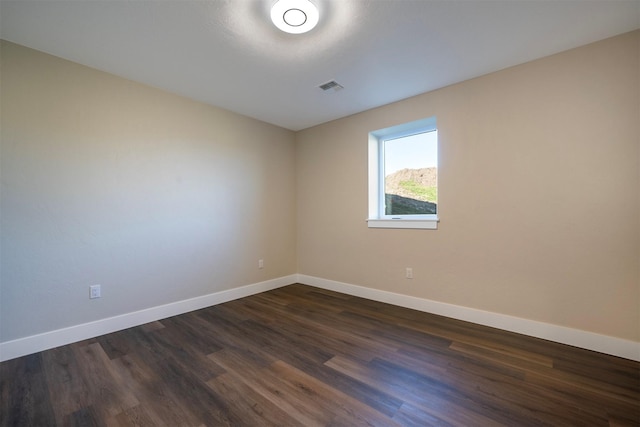 spare room featuring dark wood-type flooring