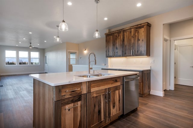 kitchen featuring ceiling fan, a center island with sink, stainless steel dishwasher, sink, and dark wood-type flooring