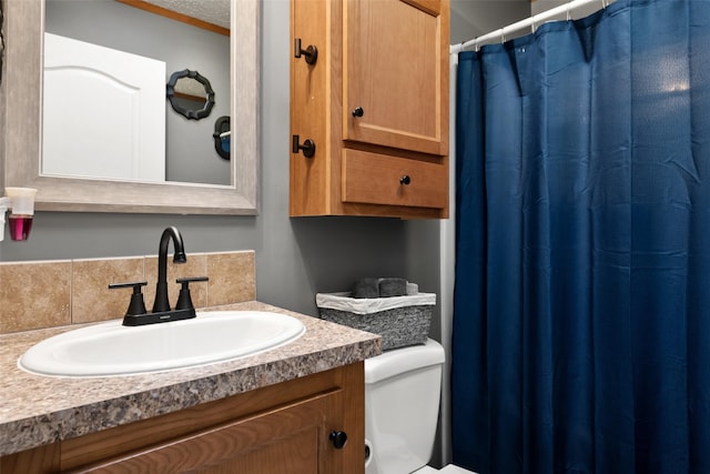 bathroom with toilet, a textured ceiling, and vanity