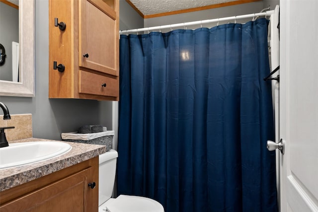 bathroom featuring a textured ceiling, toilet, and vanity