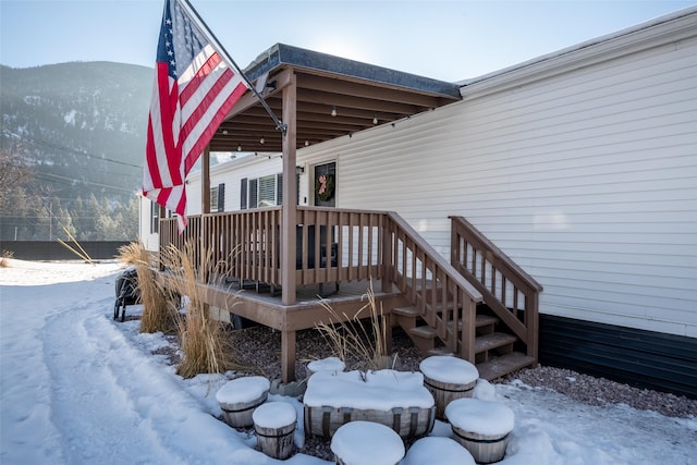 snow covered deck featuring a mountain view