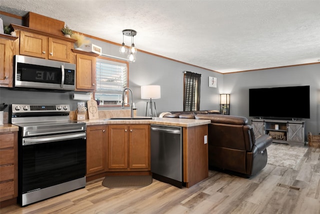 kitchen featuring appliances with stainless steel finishes, crown molding, light hardwood / wood-style floors, and sink