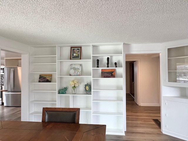 details featuring wood finished floors, freestanding refrigerator, and a textured ceiling