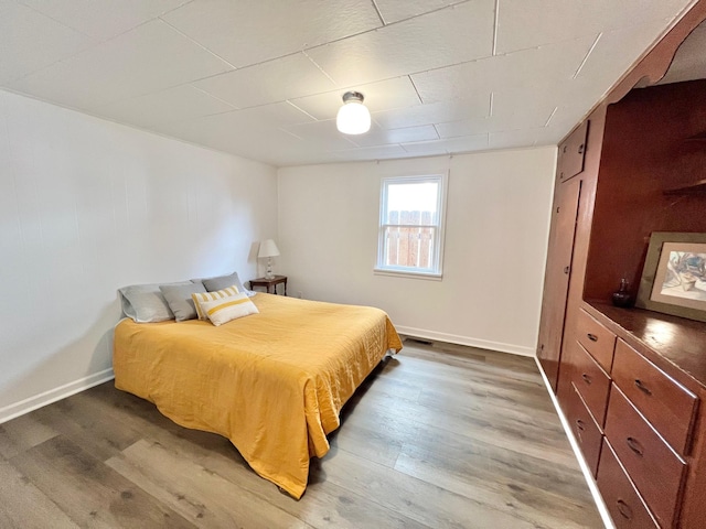 bedroom with wood finished floors and baseboards