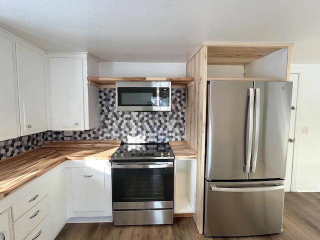 kitchen with dark wood finished floors, butcher block countertops, stainless steel appliances, white cabinets, and a textured ceiling