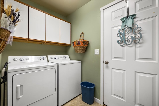 laundry area featuring cabinets, light tile patterned floors, and washing machine and clothes dryer