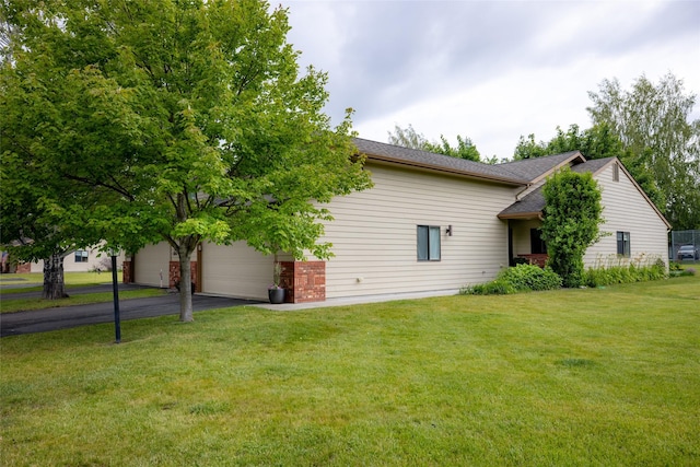 view of side of home featuring a yard and a garage