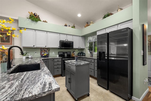 kitchen with a center island, stainless steel appliances, dark stone countertops, sink, and gray cabinets