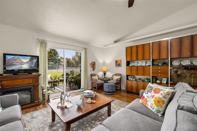 living room with lofted ceiling, ceiling fan, and hardwood / wood-style flooring