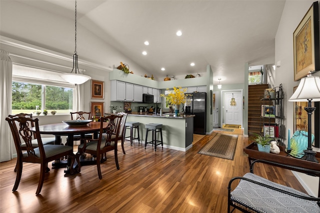 dining area with vaulted ceiling and dark hardwood / wood-style flooring