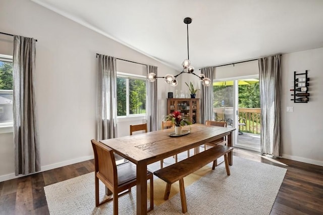 dining room with dark wood-type flooring, a wealth of natural light, and vaulted ceiling