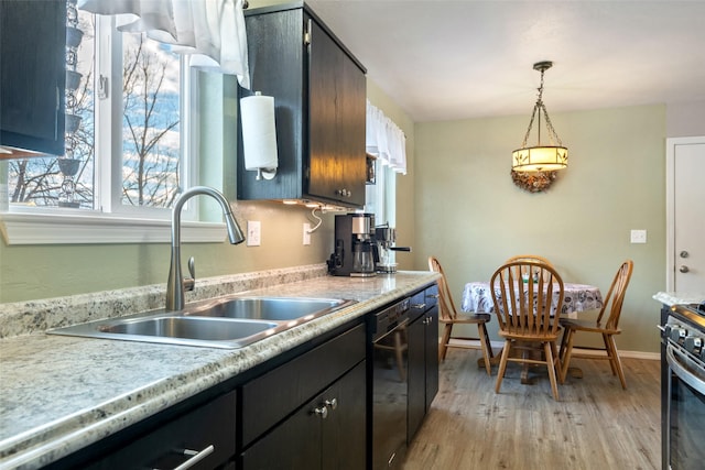 kitchen featuring dishwasher, sink, light hardwood / wood-style flooring, hanging light fixtures, and stainless steel range oven