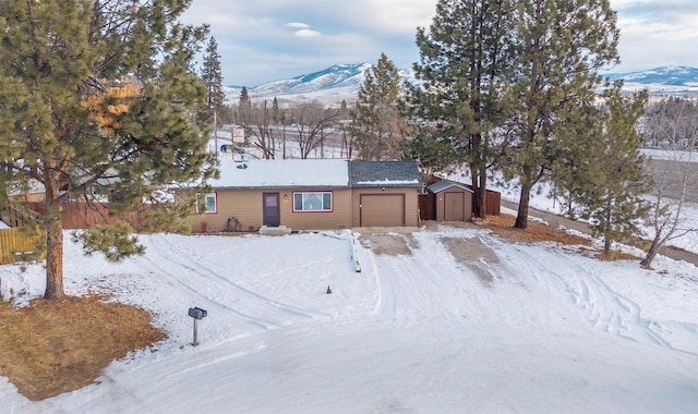 view of front of property with a mountain view and a storage shed