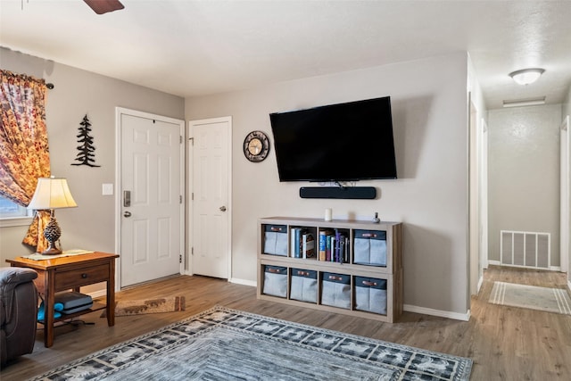 living room with hardwood / wood-style flooring and ceiling fan