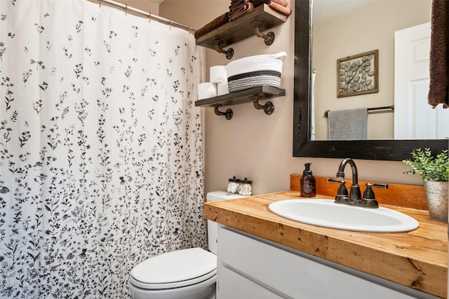 bathroom featuring toilet, vanity, and a shower with shower curtain