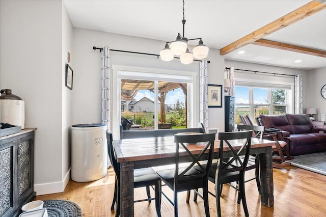 dining area featuring light hardwood / wood-style floors, a notable chandelier, and beamed ceiling