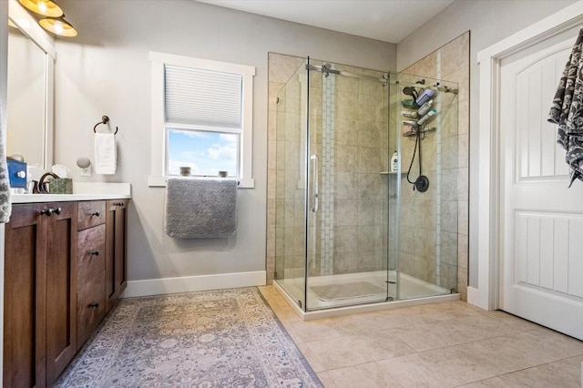 bathroom featuring a shower with shower door, vanity, and tile patterned flooring