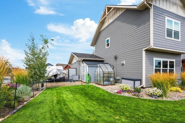 rear view of property featuring a yard and an outdoor structure