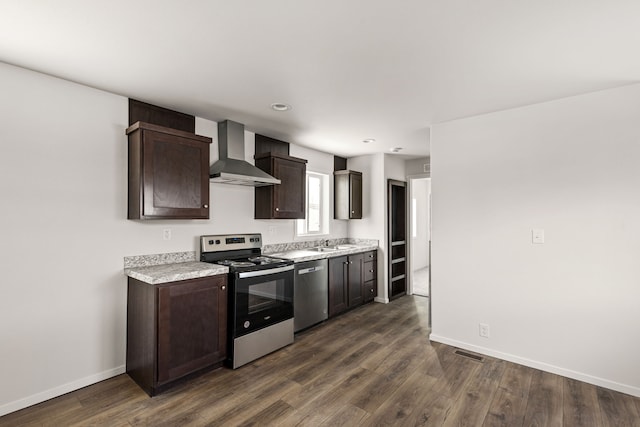 kitchen featuring appliances with stainless steel finishes, wall chimney exhaust hood, dark brown cabinets, and sink