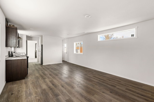 unfurnished living room with plenty of natural light and dark hardwood / wood-style flooring