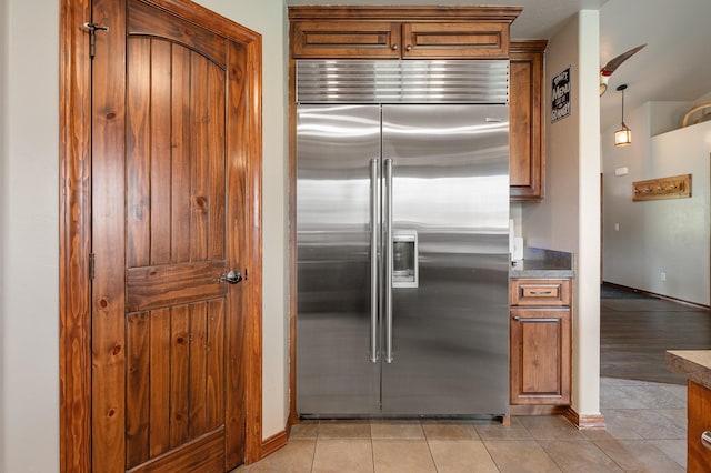 kitchen with decorative light fixtures, light tile patterned floors, and built in fridge