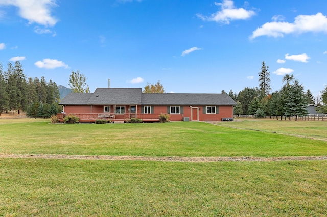 single story home featuring a front lawn and a wooden deck