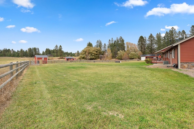 view of yard featuring a rural view, central AC, and an outdoor structure