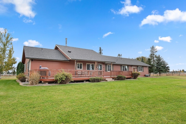 rear view of house with a wooden deck and a lawn