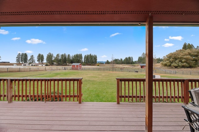 deck with an outbuilding, a rural view, and a yard