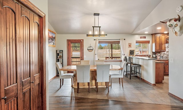 dining room featuring lofted ceiling, a chandelier, and light hardwood / wood-style flooring