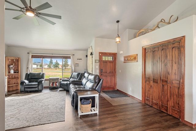 living room with ceiling fan, dark wood-type flooring, and lofted ceiling