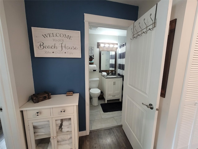 bathroom featuring toilet, wood-type flooring, and vanity