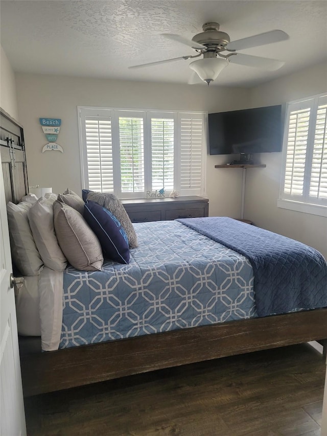 bedroom with a textured ceiling, ceiling fan, and hardwood / wood-style flooring