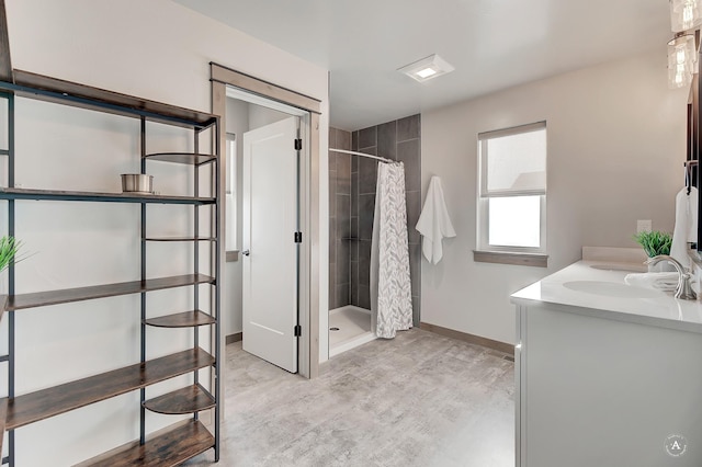 bathroom featuring a stall shower, baseboards, and vanity