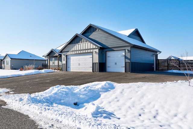 view of front of home featuring board and batten siding, fence, and an attached garage