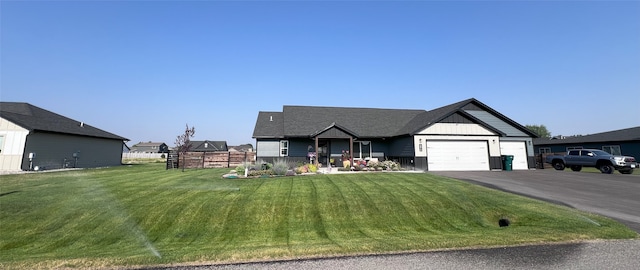 view of front of house featuring an attached garage, driveway, and a front lawn