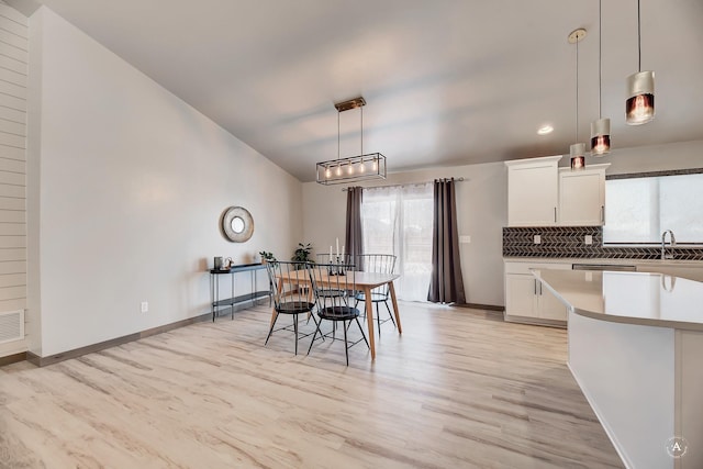 dining room featuring light wood-type flooring, baseboards, and visible vents