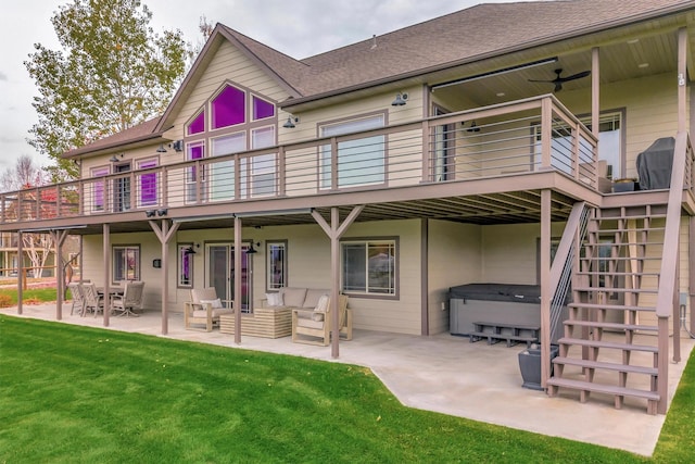 rear view of property with a hot tub, ceiling fan, a yard, a deck, and a patio