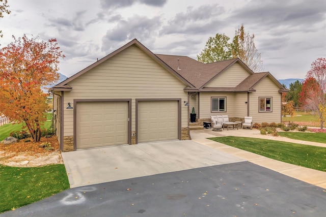 view of front of home with a front lawn, a patio, and a garage