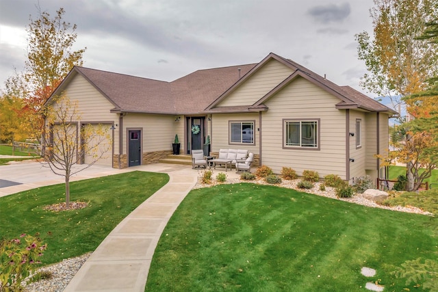 view of front facade featuring a garage, outdoor lounge area, a front yard, and a patio