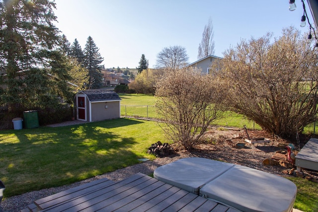view of yard featuring an outdoor structure, a deck, a shed, and fence private yard