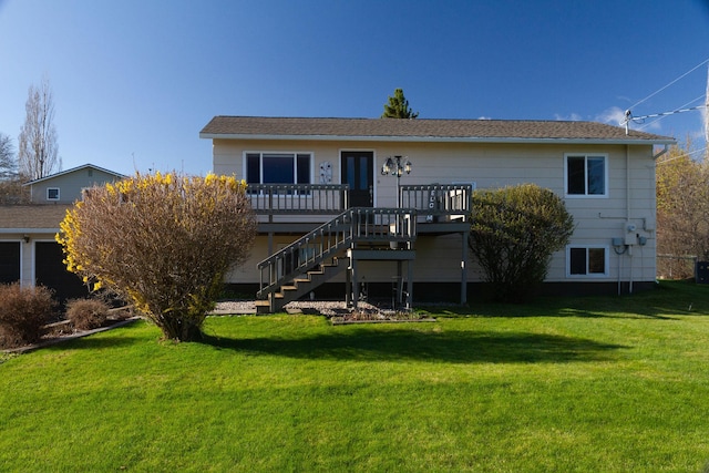 rear view of property with a yard, stairway, and a deck