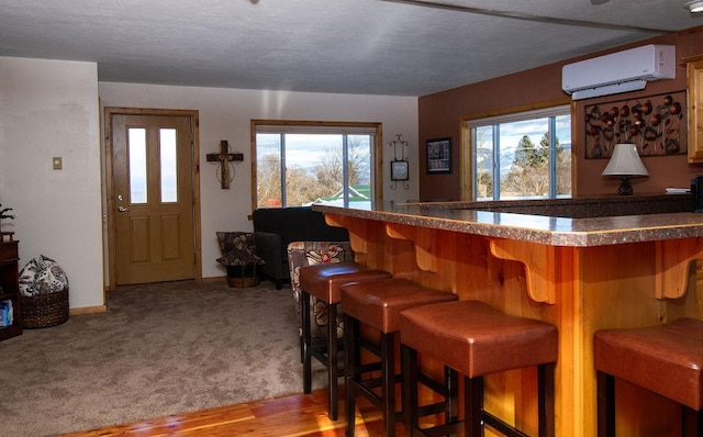 bar featuring a dry bar, baseboards, carpet floors, and a wall unit AC