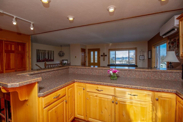 kitchen featuring dark countertops, rail lighting, and a wall mounted air conditioner