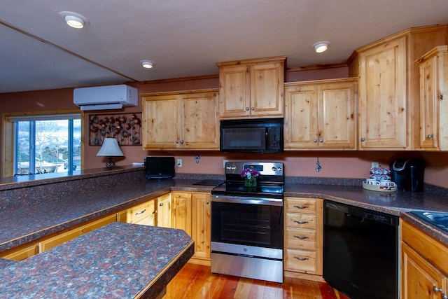 kitchen with a wall mounted air conditioner, black appliances, dark countertops, and light wood-type flooring