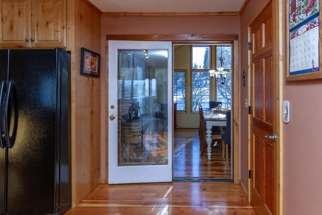 doorway to outside featuring crown molding and light wood finished floors