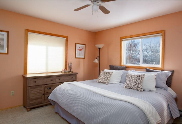 bedroom featuring ceiling fan, baseboards, and light carpet