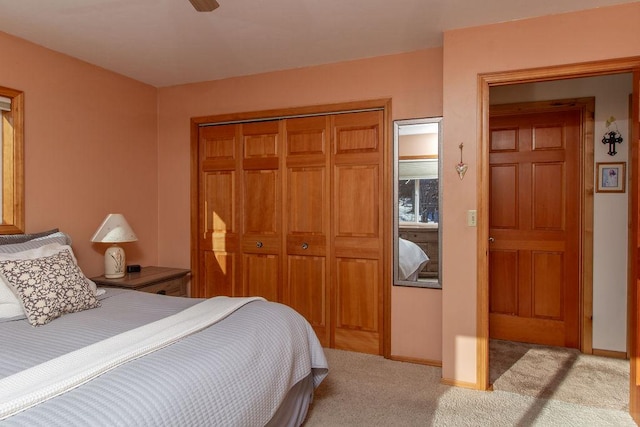 bedroom featuring baseboards, light carpet, and a closet