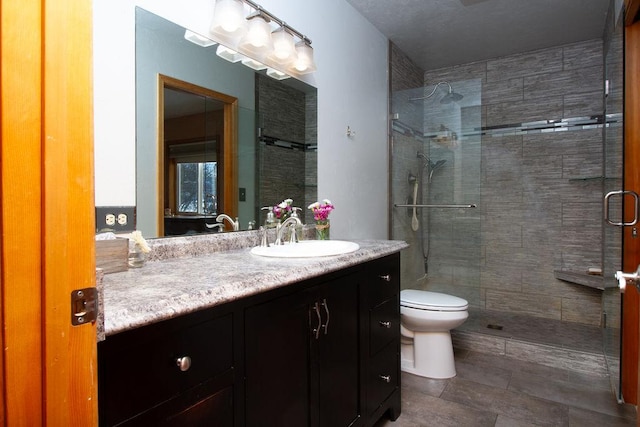 full bath featuring toilet, vanity, and a stall shower