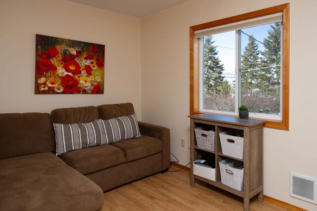 living area with wood finished floors and visible vents
